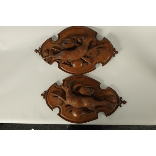 592 - A PAIR OF LATE 19TH CENTURY BLACK FOREST CARVED LINDEN WOOD PLAQUES depicting hung game on shaped mo... 