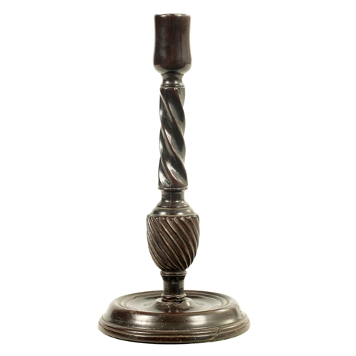 601 - AN 18TH CENTURY MAHOGANY CANDLESTICK with twisted stem and dished ring turned base. (27cm high)