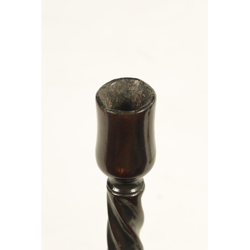 601 - AN 18TH CENTURY MAHOGANY CANDLESTICK with twisted stem and dished ring turned base. (27cm high)