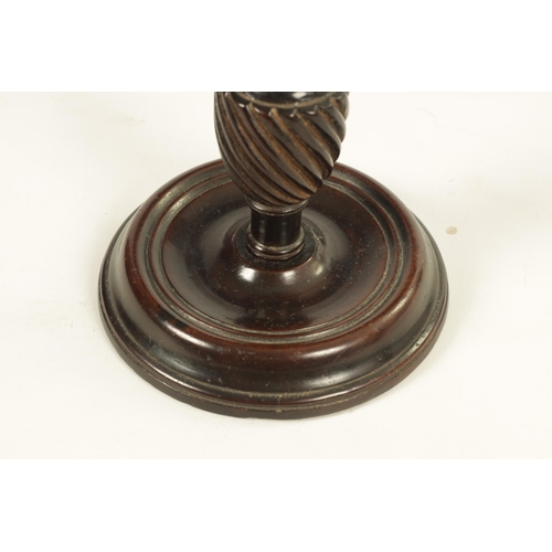 601 - AN 18TH CENTURY MAHOGANY CANDLESTICK with twisted stem and dished ring turned base. (27cm high)