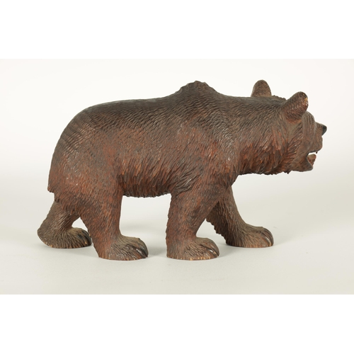 603 - AN EARLY 20TH CENTURY CARVED BLACK FOREST BEAR modelled in a standing pose with glass eyes and paint... 