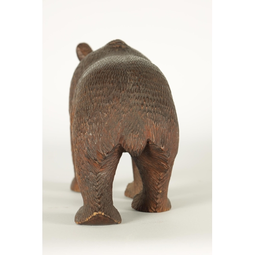 603 - AN EARLY 20TH CENTURY CARVED BLACK FOREST BEAR modelled in a standing pose with glass eyes and paint... 