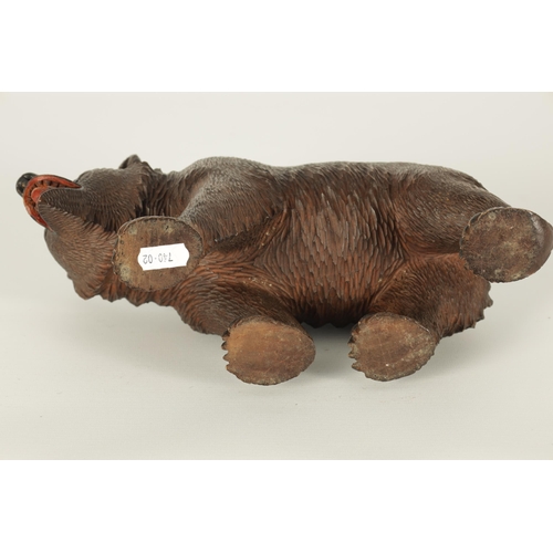 603 - AN EARLY 20TH CENTURY CARVED BLACK FOREST BEAR modelled in a standing pose with glass eyes and paint... 