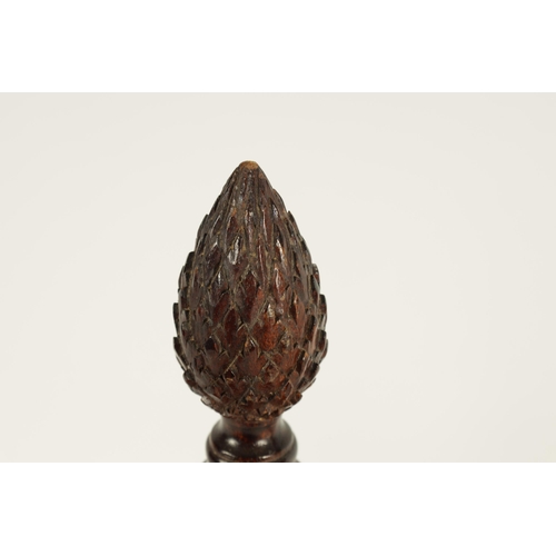 611 - A 19TH CENTURY MAHOGANY DECANTER STAND with pineapple finial and ring turned stem, above a four divi... 