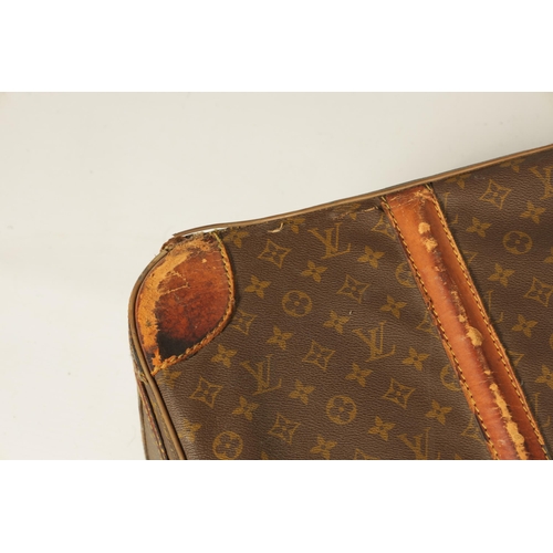 634 - A VINTAGE LOUIS VUITTON SUITCASE with a monogram covering and tan leather straps (78cm wide 53cm dee... 