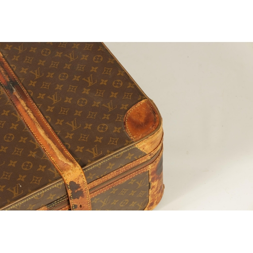 634 - A VINTAGE LOUIS VUITTON SUITCASE with a monogram covering and tan leather straps (78cm wide 53cm dee... 