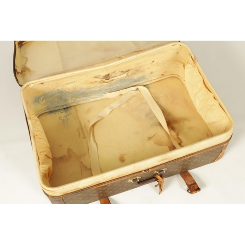 634 - A VINTAGE LOUIS VUITTON SUITCASE with a monogram covering and tan leather straps (78cm wide 53cm dee... 