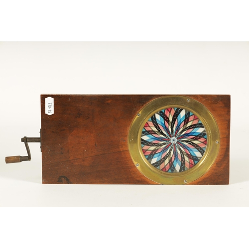 639 - A 19TH CENTURY MAHOGANY AND BRASS FRAMED COLOURED GLASS KALEIDOSCOPE of handle wound double disc swi... 