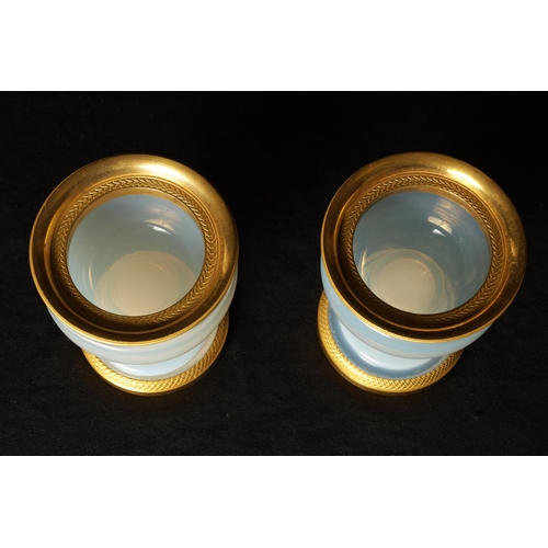 644 - A PAIR OF EARLY 19TH CENTURY FRENCH ORMOLU MOUNTED WHITE OPALINE GLASS CUPS of squat bulbous form ra... 