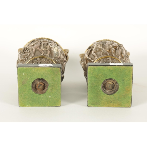 647 - A PAIR OF LATE 19TH CENTURY BRONZE AND SILVERED BRONZE GRAND TOUR URNS with stylised handles and sho... 