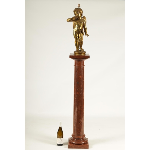 649 - AN EARLY 20TH CENTURY GILT BRONZE FIGURAL LAMP ON ROUGE MARBLE PEDESTAL the lamp modelled as Cupid s... 