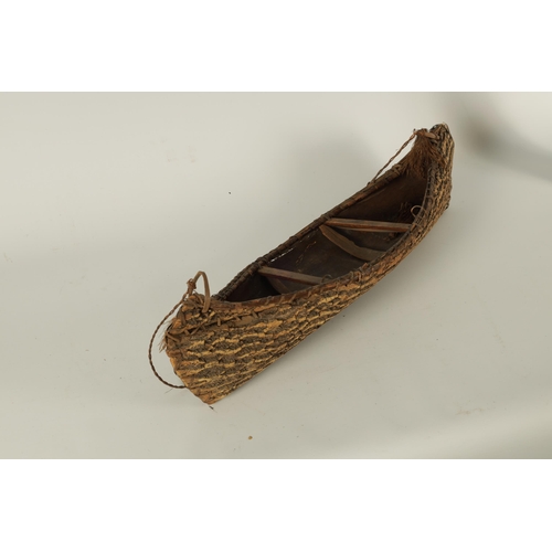 658 - A 19TH CENTURY NATIVE CANOE MODEL constructed from curved stitched tree bark with slatted cross piec... 