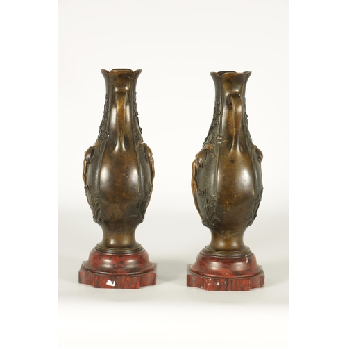 667 - E PROVOST A PAIR OF LATE 19TH CENTURY BRONZE TWO HANDLED FLATTENED OVOID VASES ON ROUGE MARBLE BASES... 