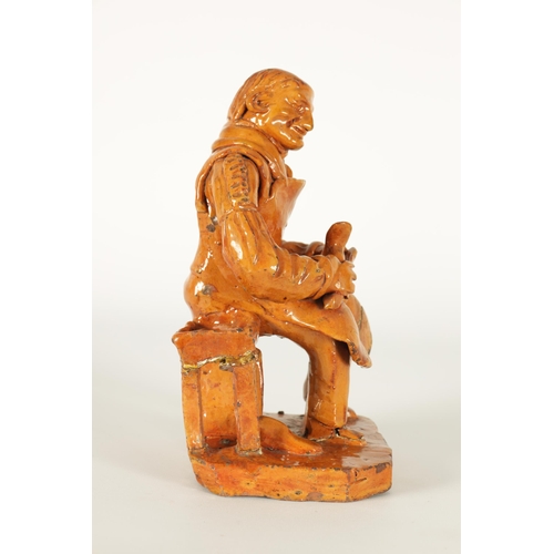 68 - A MID 19TH CENTURY PILL POTTERY WELSH REDWARE GLAZED EARTHENWARE FIGURE modelled as a seated cobbler... 