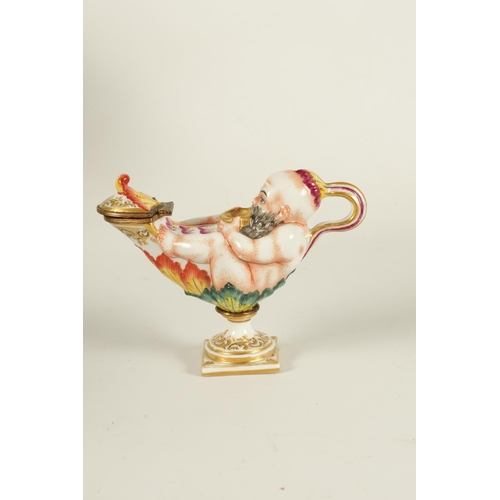 69 - A 19TH CENTURY ITALIAN CAPODIMONTE PORCELAIN INKWELL modelled as a genie and lamp, gilt and hand pai... 