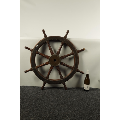 702 - A LATE 19TH CENTURY BRASS MOUNTED OAK SHIP'S WHEEL BY BROWN BOTHERS, EDINBURGH having eight turned s... 