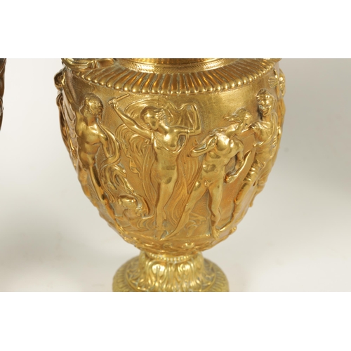 719 - TWO 19TH CENTURY FRENCH BRASS AND COPPER ROMANESQUE TWO-HANDLED URNS with figural centre bands (29cm... 