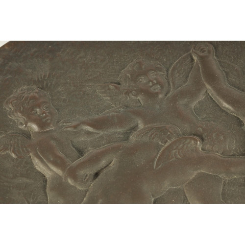 724 - A 19TH CENTURY FRENCH PATINATED BRONZE OVAL PLAQUE OF LARGE SIZE depicting cherubs in a dancing purs... 