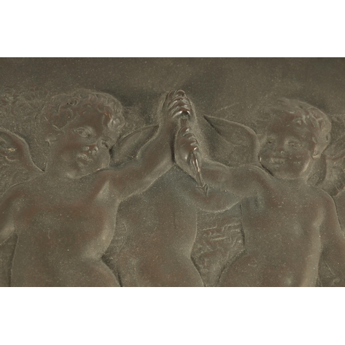 724 - A 19TH CENTURY FRENCH PATINATED BRONZE OVAL PLAQUE OF LARGE SIZE depicting cherubs in a dancing purs... 