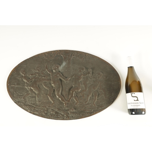 724 - A 19TH CENTURY FRENCH PATINATED BRONZE OVAL PLAQUE OF LARGE SIZE depicting cherubs in a dancing purs... 