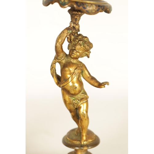 729 - A PAIR OF 19TH CENTURY FRENCH FIGURAL GILT BRONZE AND CHAMPLEVE ENAMEL CANDLESTICKS modelled as two ... 