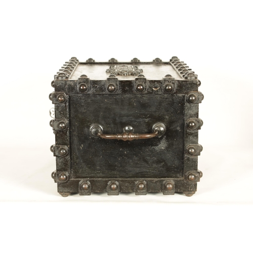 734 - A 19TH CENTURY CAST IRON STRONG BOX with riveted body and coat of arms to the front - in working con... 