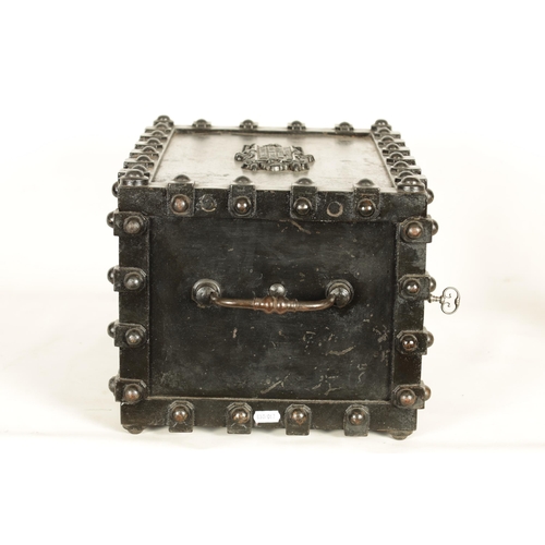 734 - A 19TH CENTURY CAST IRON STRONG BOX with riveted body and coat of arms to the front - in working con... 