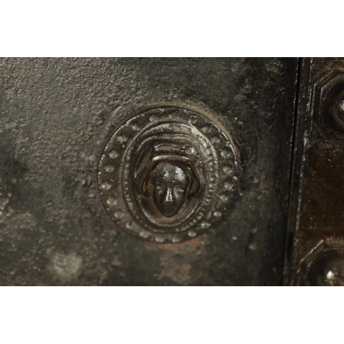 734 - A 19TH CENTURY CAST IRON STRONG BOX with riveted body and coat of arms to the front - in working con... 