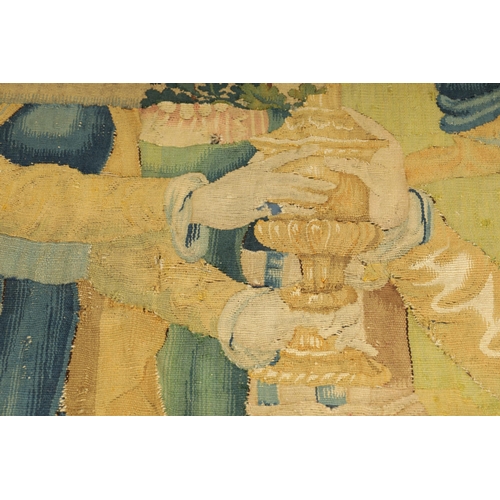 746 - A 17TH CENTURY WALL HANGING TAPESTRY worked with figures in a garden landscape setting; within a blu... 