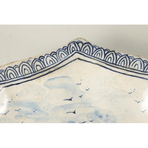 81 - AN 18TH/19TH CENTURY DELFT BLUE AND WHITE SHAPED SHALLOW DISH with lake and landscape centre depicti... 