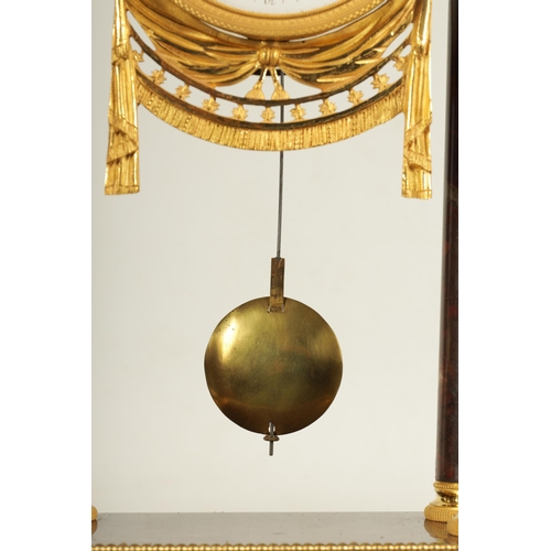 974 - AN EARLY 19TH CENTURY FRENCH ROUGE MARBLE AND ORMOLU PORTICO MANTEL CLOCK the break arched top surmo... 