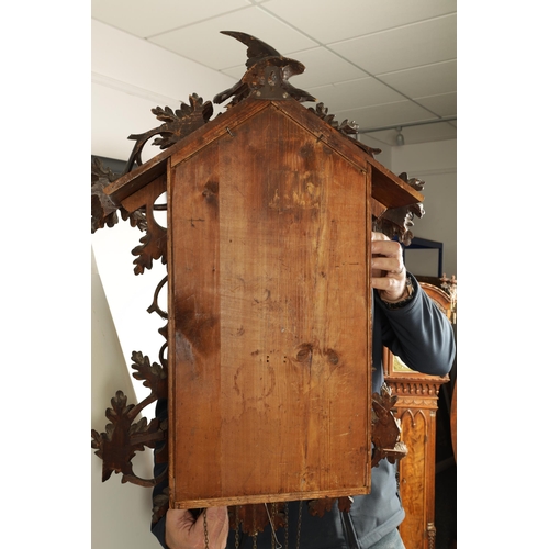 992 - A LARGE 19TH CENTURY THREE-TRAIN MUSICAL CUCKOO CLOCK the carved leafwork case surmounted by an eagl... 