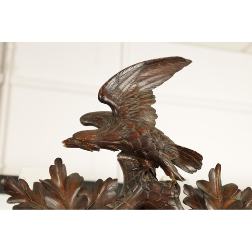 992 - A LARGE 19TH CENTURY THREE-TRAIN MUSICAL CUCKOO CLOCK the carved leafwork case surmounted by an eagl... 