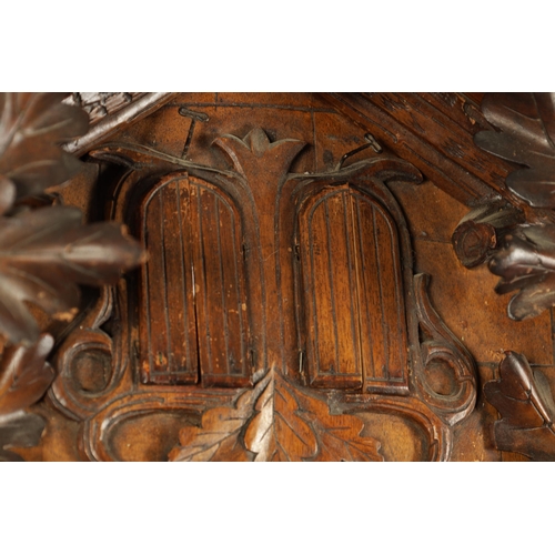 992 - A LARGE 19TH CENTURY THREE-TRAIN MUSICAL CUCKOO CLOCK the carved leafwork case surmounted by an eagl... 