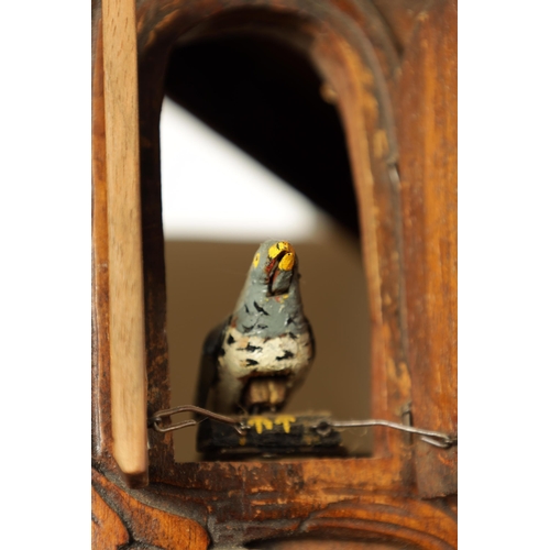 992 - A LARGE 19TH CENTURY THREE-TRAIN MUSICAL CUCKOO CLOCK the carved leafwork case surmounted by an eagl... 