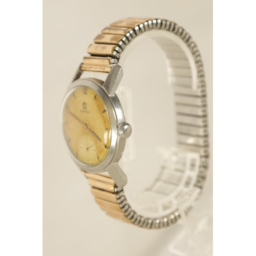 325 - A GENTLEMAN'S 1950's STEEL OMEGA WRIST WATCH on later bracelet, the discoloured champagne dial with ... 