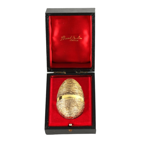 352 - A 1991 STUART DEVLIN SILVER GILT NOVELTY EGG the textured body with a plain girdle opening to reveal... 