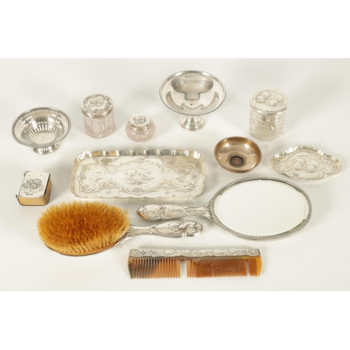 366 - AN ART NOVEAU SILVER NINE PIECE DRESSING TABLE SET decorated with winged chuerbs hallmarked William ... 