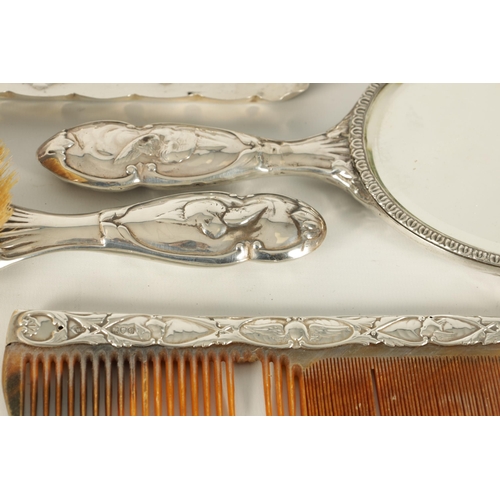 366 - AN ART NOVEAU SILVER NINE PIECE DRESSING TABLE SET decorated with winged chuerbs hallmarked William ... 