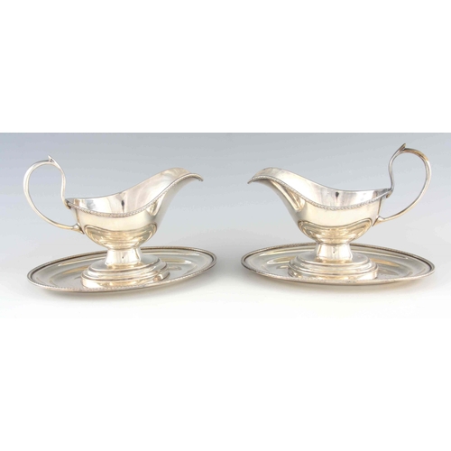 370 - A LARGE PAIR OF 19TH CENTURY SILVER PLATED SAUCE BOATS ON FIXED STANDS with feathered borders 25cm w... 