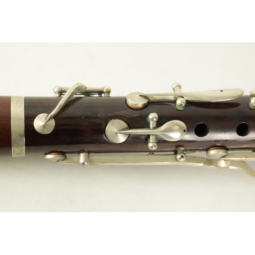 102 - A VINTAGE ROSEWOOD CLARINET with silvered fittings and banded mounts in fitted blue velvet-lined lea... 