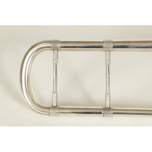 109 - A MID 20TH CENTURY SILVERED BRASS AND BRIGHT CUT MOUNTED CASED TROMBONE with engraved titled floral ... 