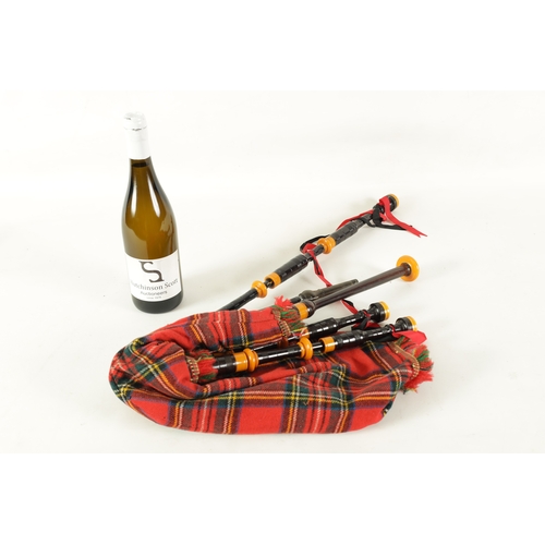 128 - A SET OF SCOTTISH BAGPIPES having a tartan covered bag and turned wooden pipes