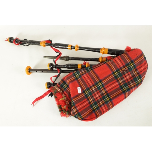 128 - A SET OF SCOTTISH BAGPIPES having a tartan covered bag and turned wooden pipes