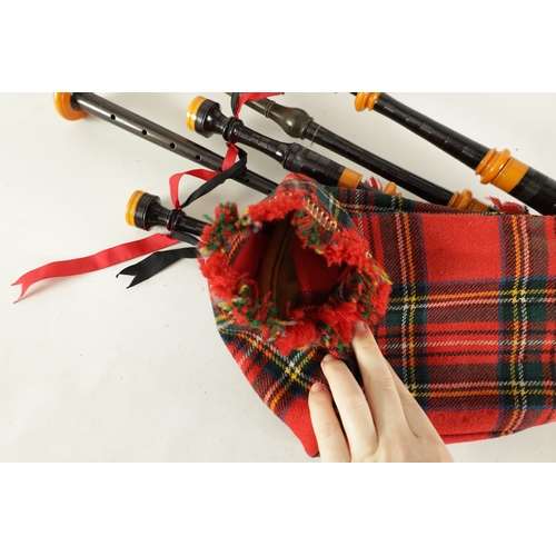 128 - A SET OF SCOTTISH BAGPIPES having a tartan covered bag and turned wooden pipes