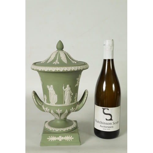 110 - A WEDGWOOD GREEN JASPER WARE TWO-HANDLED URN SHAPED VASE AND COVER ON PEDESTAL BASE decorated with a... 