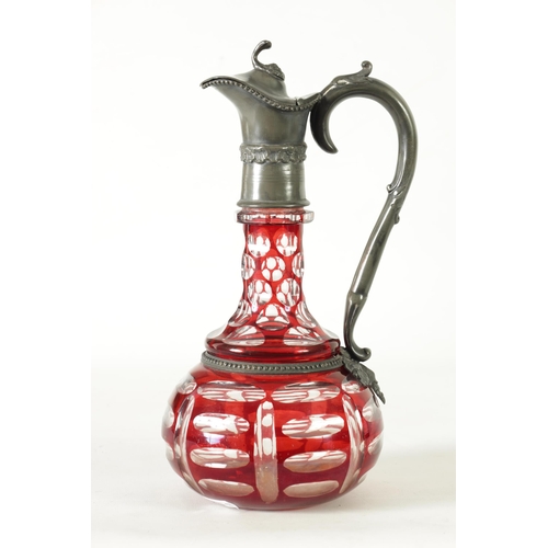 24 - A 19TH CENTURY BOHEMIAN GLASS CLARET JUG of cut red glass overlay design with pewter mounts. (27cm h... 