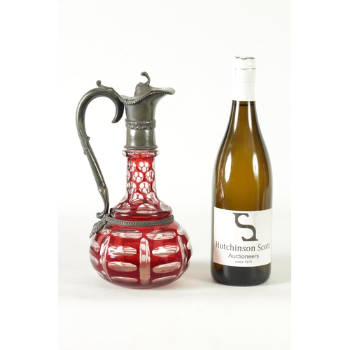 24 - A 19TH CENTURY BOHEMIAN GLASS CLARET JUG of cut red glass overlay design with pewter mounts. (27cm h... 