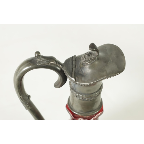 24 - A 19TH CENTURY BOHEMIAN GLASS CLARET JUG of cut red glass overlay design with pewter mounts. (27cm h... 