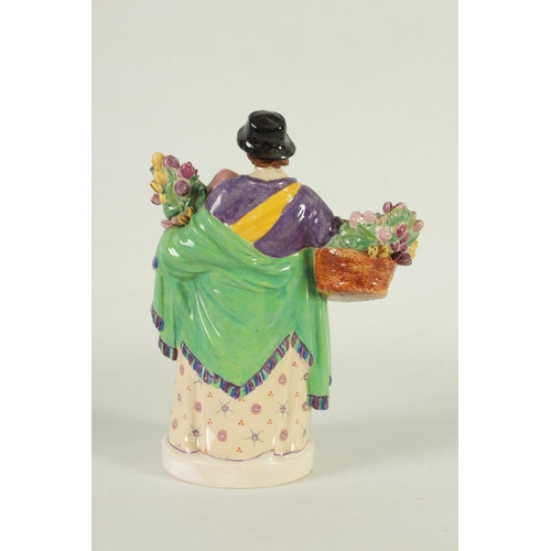 81 - CHARLES VYSE - 1922 A finely modelled earthenware FIGURE depicting a flower seller colourfully decor... 